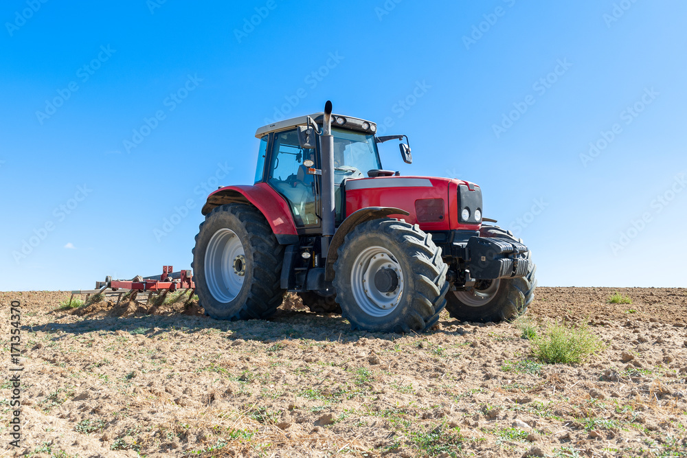 agricultural tractor in the foreground with blue sky background. agricultural tractor in the foreground with blue sky background.