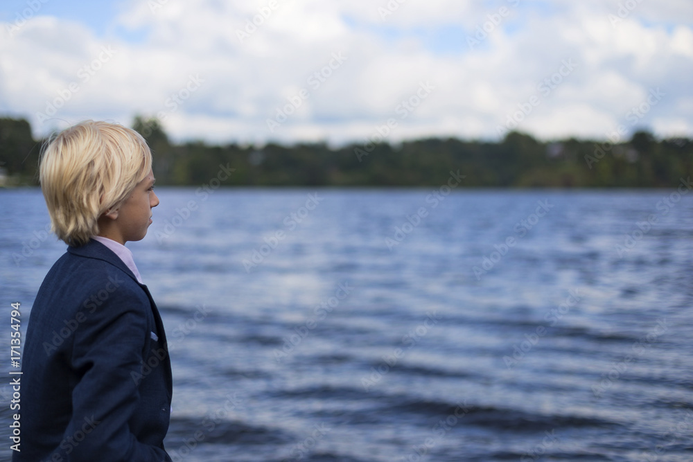 the boy on the river Bank looking into the distance