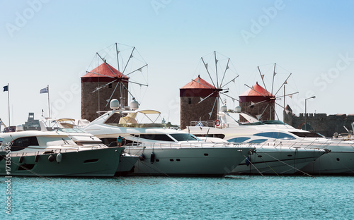 Ancient windmills and yachts in port of Rhodes town on Rhodes island, Greece