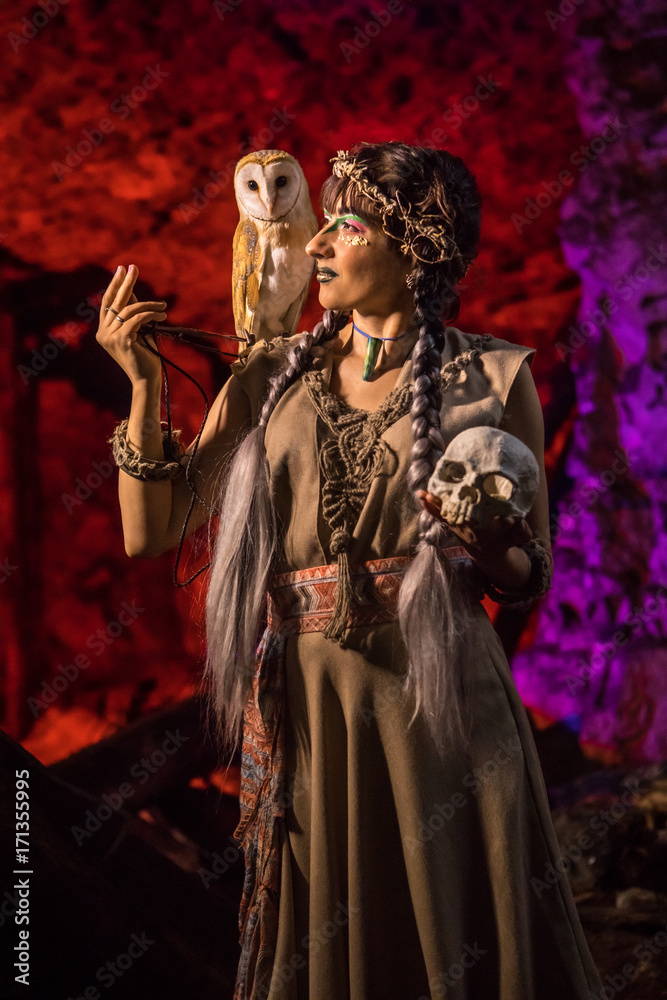 Beautiful witch with the white owl and skull in the hand.