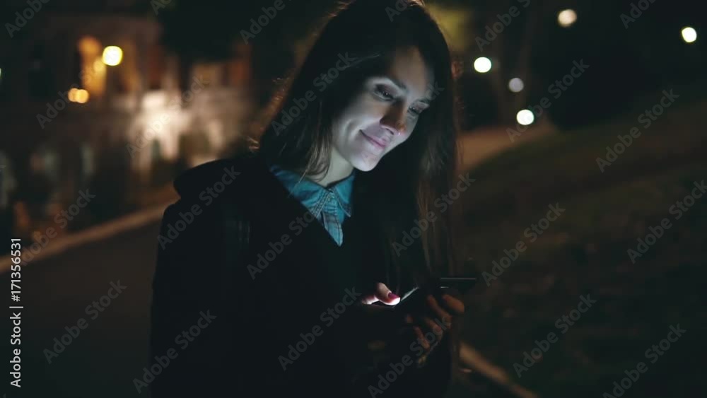 Slow motion. Happy young woman walking in the park near the Colosseum in Rome, Italy and using the smartphone. Slow motion. Happy young woman walking in the park near the Colosseum in Rome, Italy and using the smartphone.