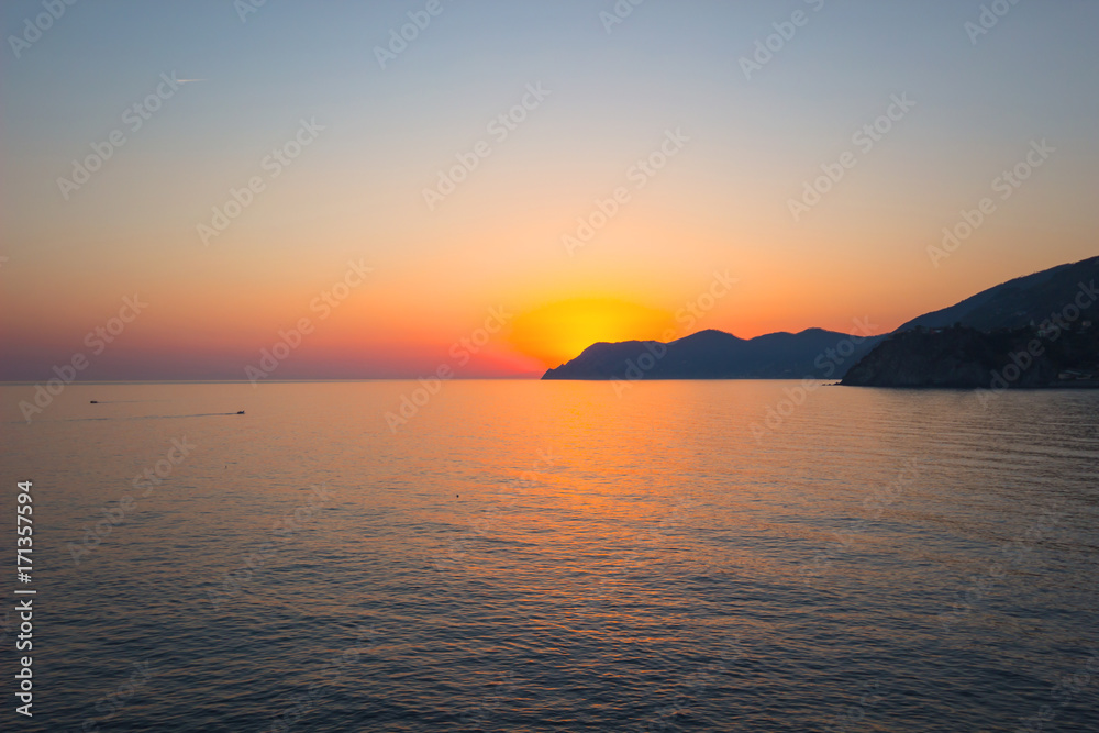Natural Sunset, Sunrise over sea, mountain Bright Dramatic Sky And Dark Ground. Countryside Landscape Under Scenic Colorful Sky At Sunset Dawn Sunrise. Sun Over Skyline, Horizon. Warm Colours.