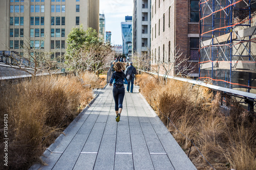 Inspiring shot of woman jogging on New York City High Line walkway photo