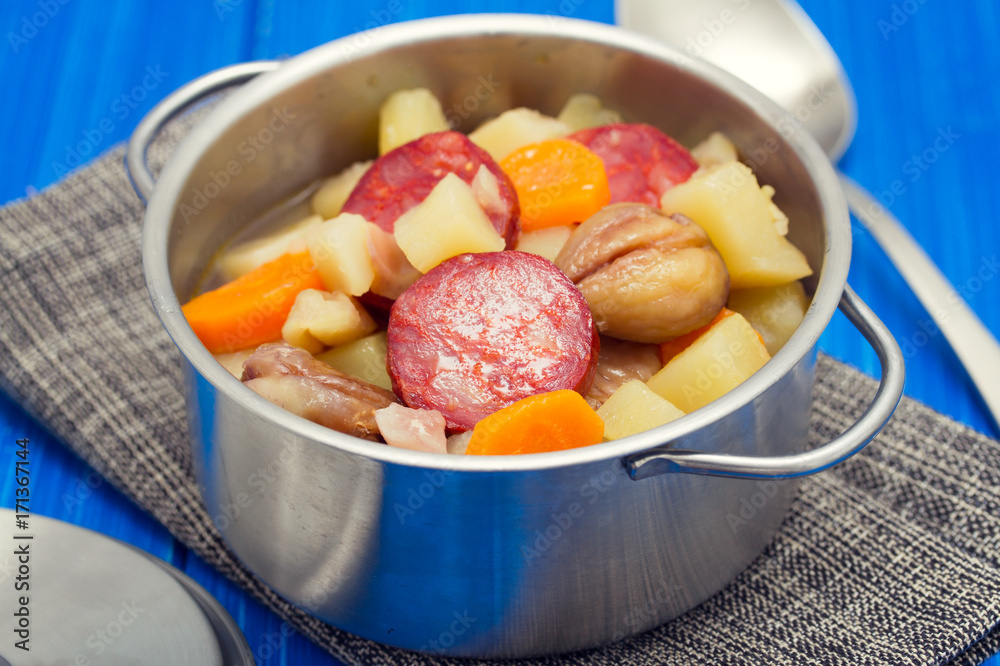 soup chestnuts with smoked sausage in pot on wooden background soup chestnuts with smoked sausage in pot on wooden background