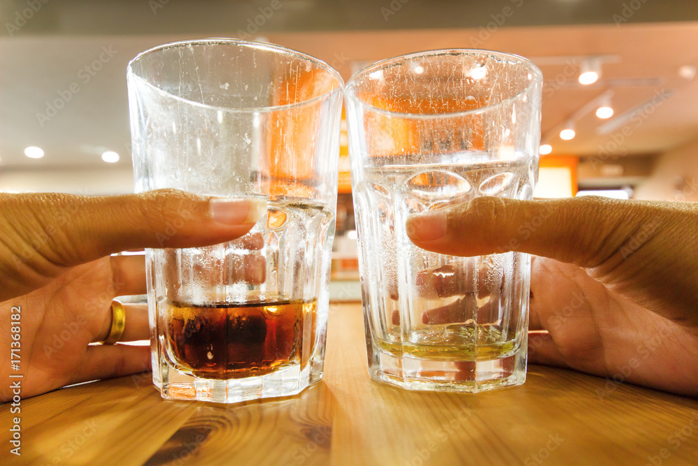 Hand holding a glass of water on the table background. Hand holding a glass of water on the table background.