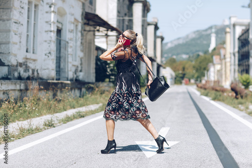 Young business woman with handbag running to catch the plane or train. Elegant trendy clothing. Hurrying to work concept.