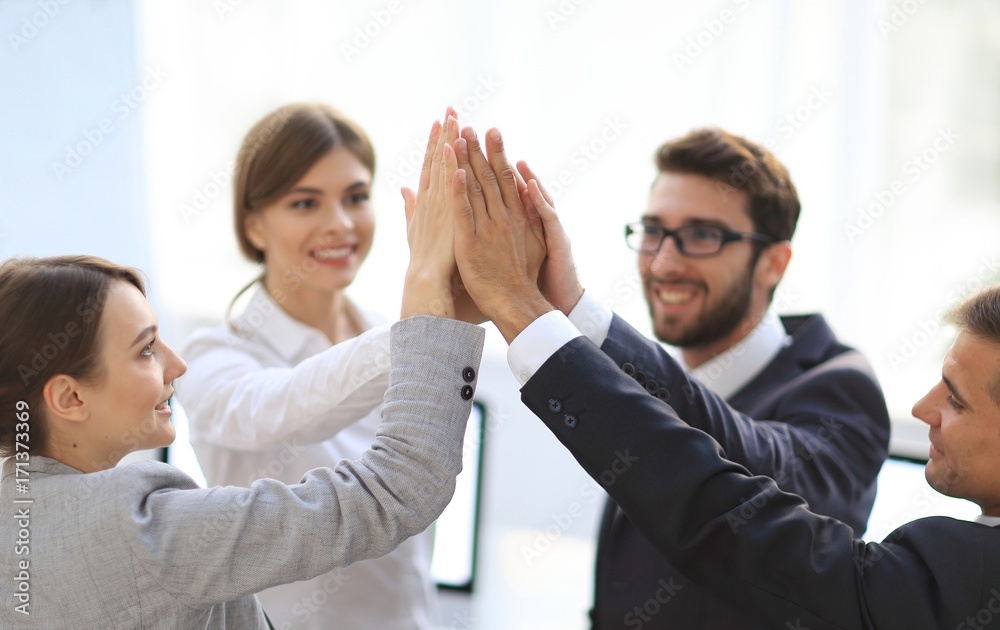 successful business team giving each other a high-five, standing in the office successful business team giving each other a high-five, standing in the office