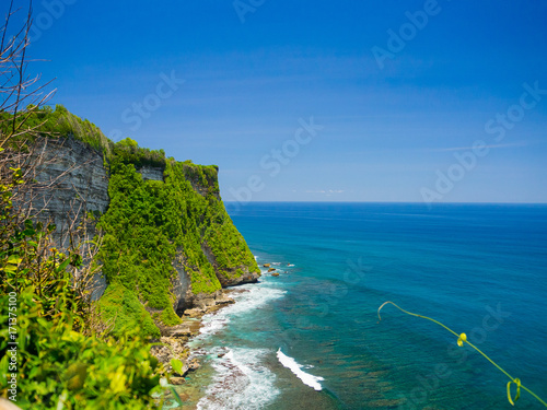 Amazing view of steep cliff and ocean at Uluwatu in Bali, Indonesia photo