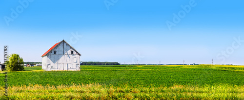 Panoramic farmland with white barn