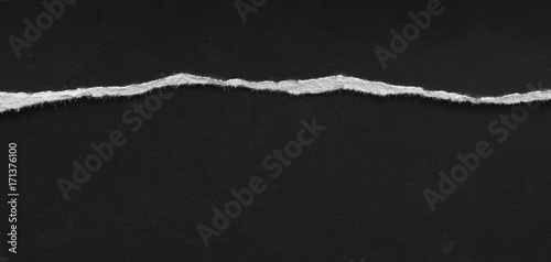 Ripped paper on black background, space for advertising copy.