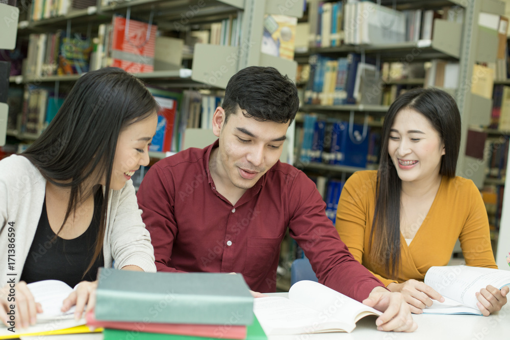 Group of Student reading books in the library with attractive smiling together . People with Education concept. Group of Student reading books in the library with attractive smiling together . People with Education concept.