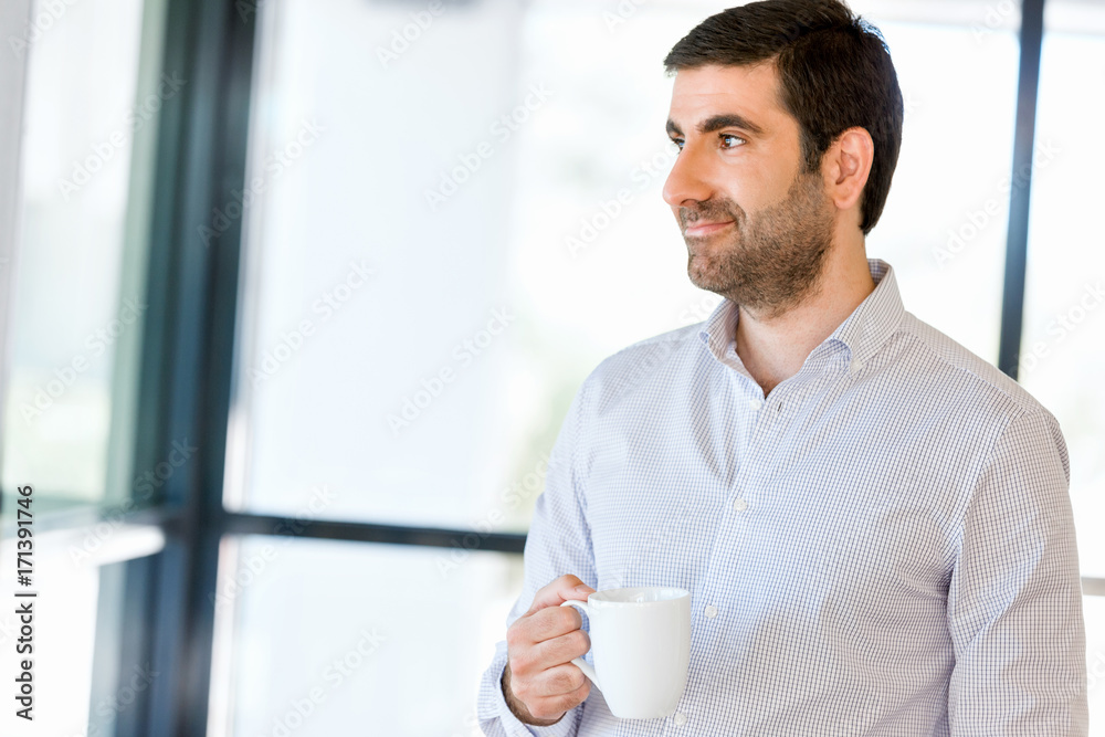 Young businessman in office with a mug
