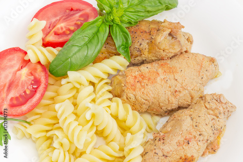 Stuffed meat roulades, spiral pasta and tomato closeup photo