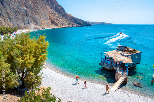 Fototapeta Naklejka Na Ścianę i Meble -  Glyka Nera beach (Sweet Water or Fresh Water). View of the remote and famous Sweet Water Beach in south Crete, with its unique tavern on the rock inside sea. This is a nudist beach.