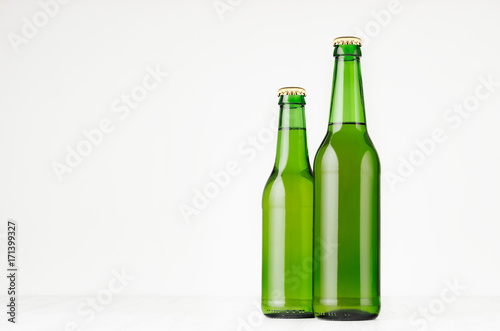 Group green longneck beer bottles 330ml, mock up. Template for advertising, design, branding identity on white wood table.