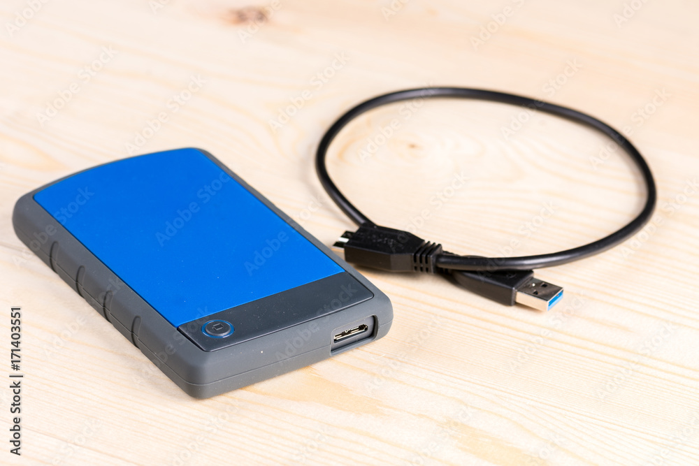External hard disc hdd with usb cable on the wooden board table External hard disc hdd with usb cable on the wooden board table