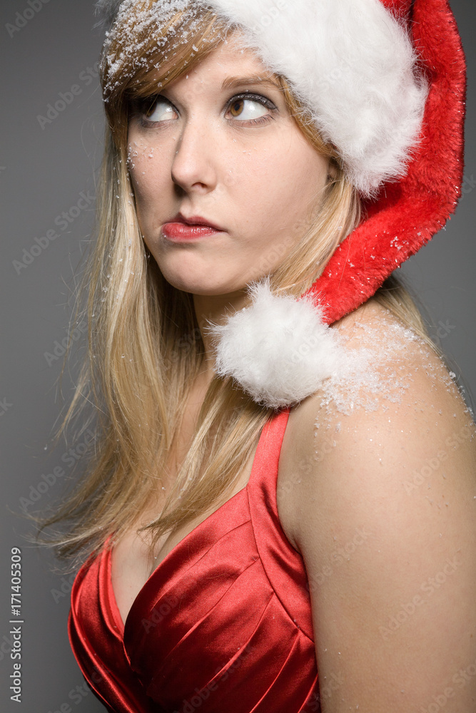 Hübsches Mädchen mit Weihnachtmütze überlegt Hübsches Mädchen mit Weihnachtmütze überlegt