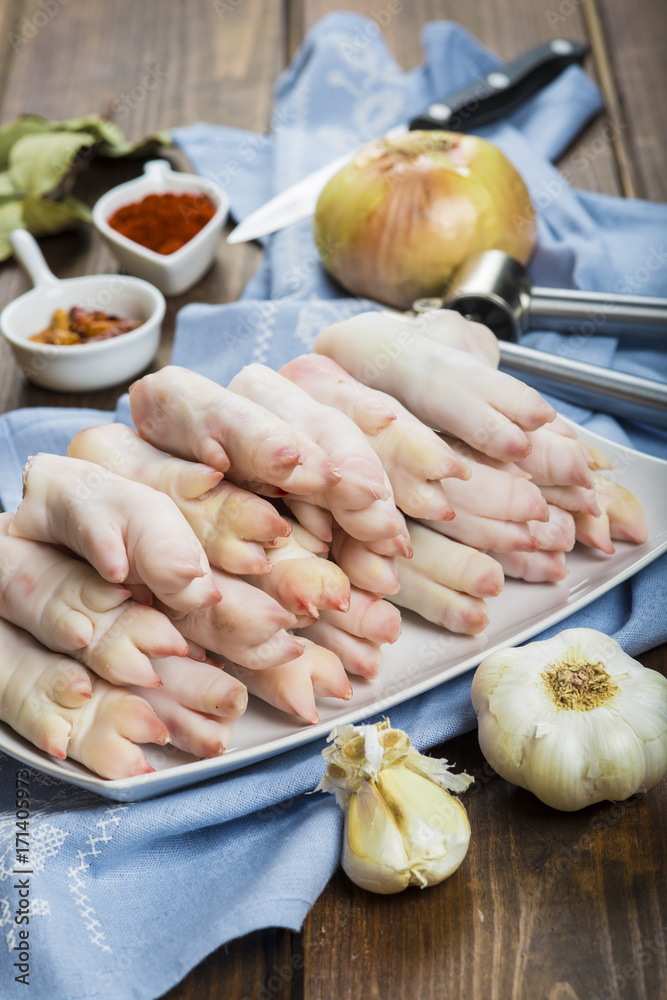 Bandeja con manitas de cochinillo, carne de cerdo e ingredientes para la cocina de platos tradicionales Bandeja con manitas de cochinillo, carne de cerdo e ingredientes para la cocina de platos tradicionales