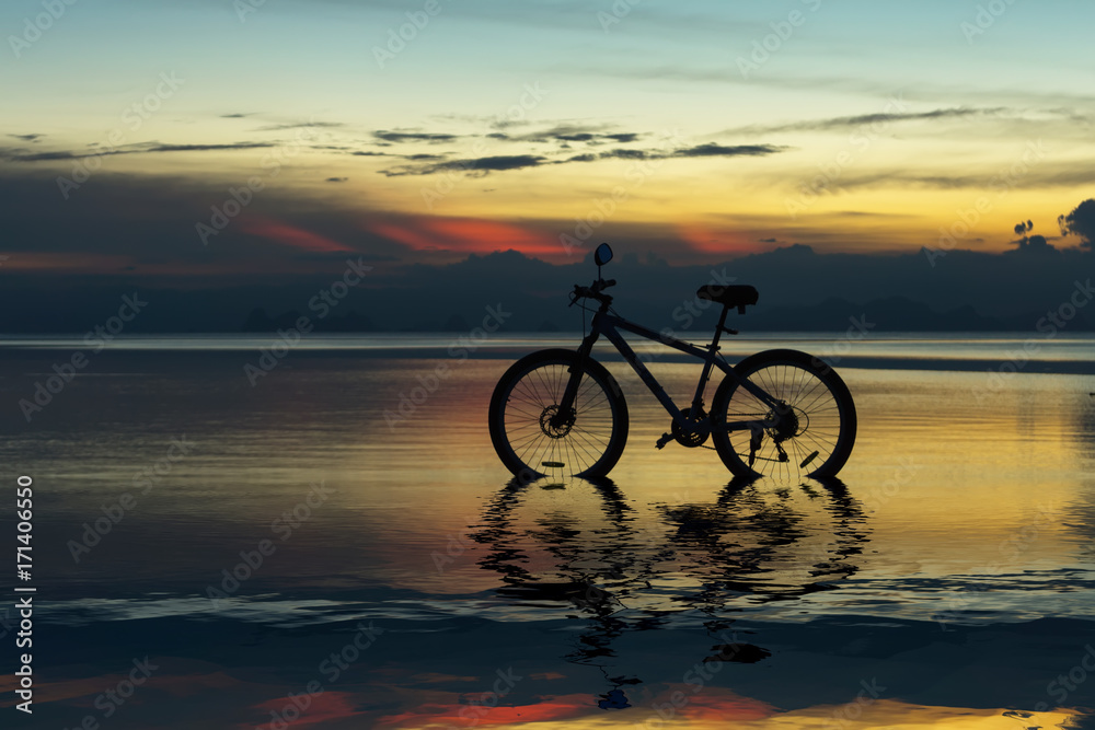 Fototapeta premium Silhouette of a bike on a lake at twilight.