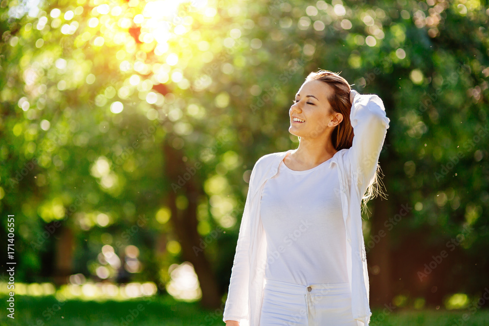 Beautiful woman in nature enjoying weather