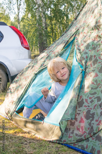 Obraz na płótnie Sleepy blond boy gets out a tent in a morning w salonie