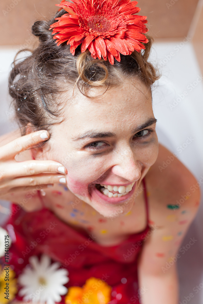 Naklejka premium young woman having fun smearing her makeup in a bathtub 