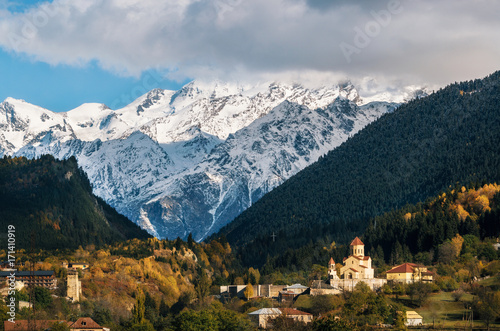 View of Svanetian towers and church in Mestia village against mountains with glaciers snow peaks. Upper Svaneti  Georgia. Georgian landmark