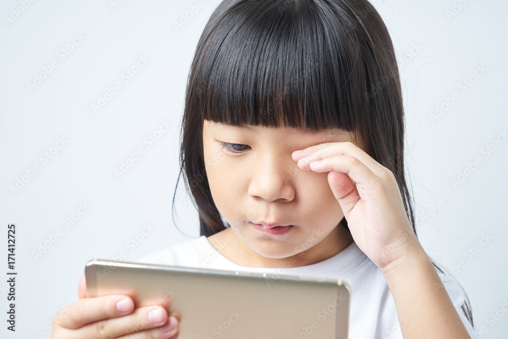 Little asian chinese girl using smartphone long time and eye feel tired. Little asian chinese girl using smartphone long time and eye feel tired.