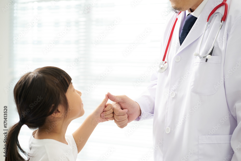 Unknown doctor and little girl shaking hands . Unknown doctor and little girl shaking hands .