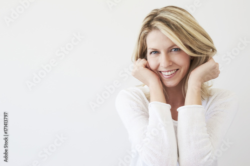 Blue eyed blond woman smiling in white, portrait