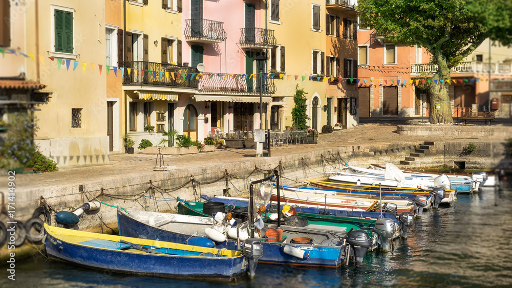 Gardasee Brenzone der kleine Hafen in der Abendsonne. Bunte Häuser, bunte Boote, Italienisches Flair. 
