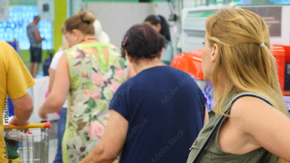 The queue of people standing at the checkout in the supermarket. 4k, slow motion