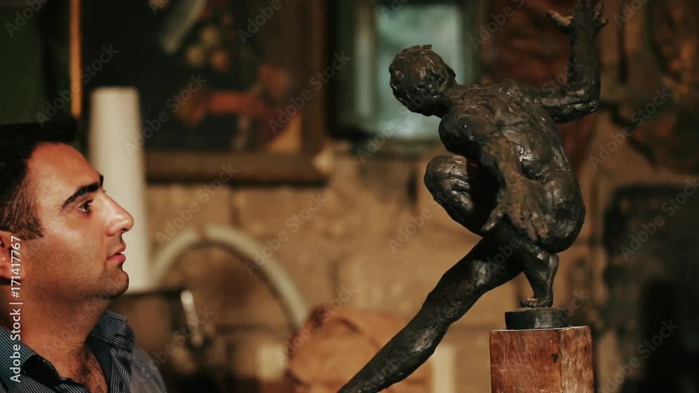 Sculptor working on a monument made of clay Sculptor working on a monument made of clay