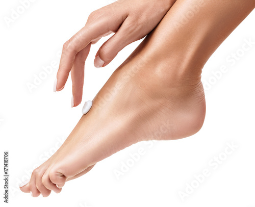 Woman applying cream on her beautiful feet.