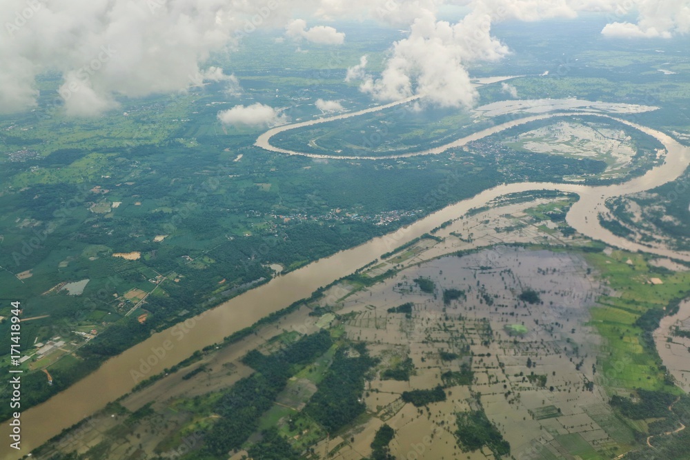 Aerial view of flood area in northeastern of thailand, view from airplane window in the morning. Soft focus.