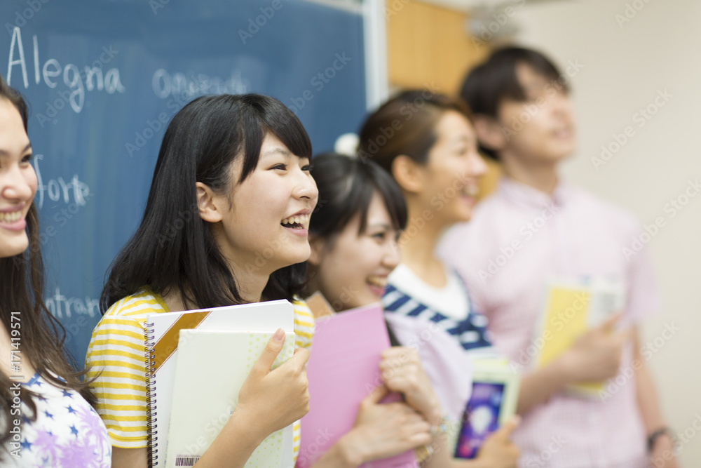 College Students Standing in front of Blackboard in Classroom College Students Standing in front of Blackboard in Classroom