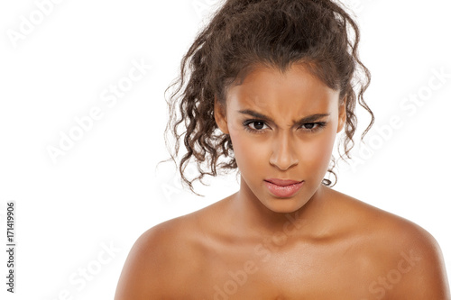 Photo Portrait of a beautiful young dark-skinned scowling woman on a white background