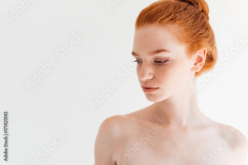 Close up picture of attractive naked ginger woman looking away