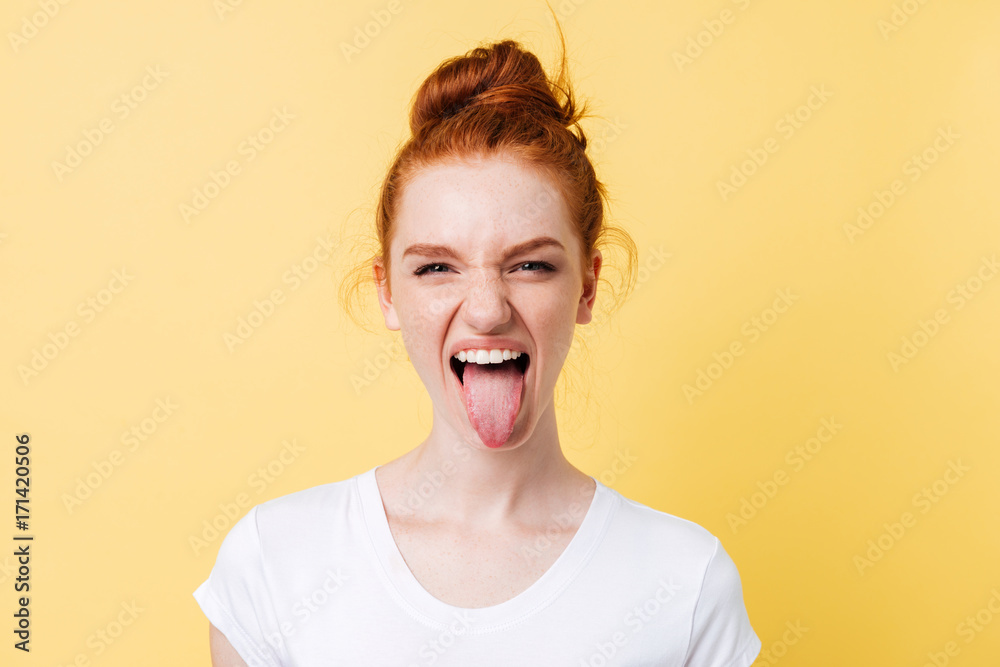 Funny ginger woman showing tongue and looking at the camera Funny ginger woman showing tongue and looking at the camera