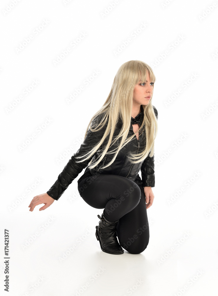 full length portrait of a blonde girl wearing black leather pose, crouching pose on white background. full length portrait of a blonde girl wearing black leather pose, crouching pose on white background.