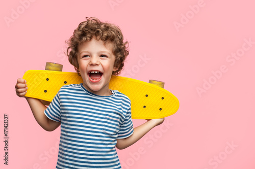 Cheerful boy with yellow longboard