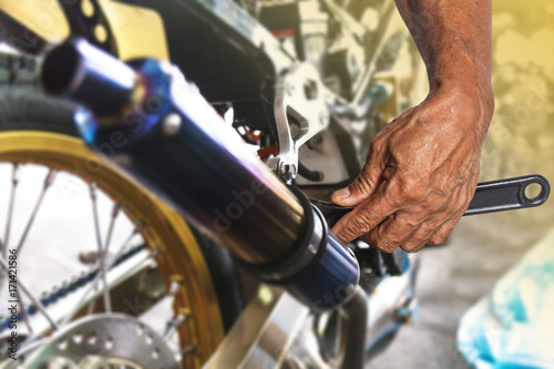 Hand with wrench, Professional mechanic repair and modifications to motorcycle