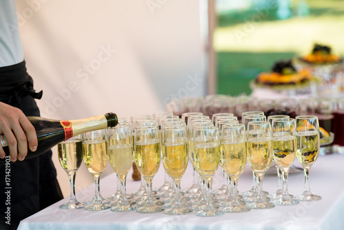 Fotótapéta Waiter is pouring champagne outdoor