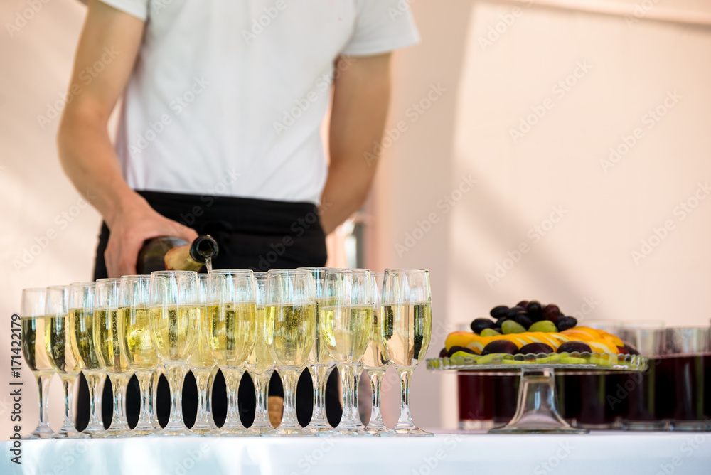 Waiter is pouring champagne outdoor