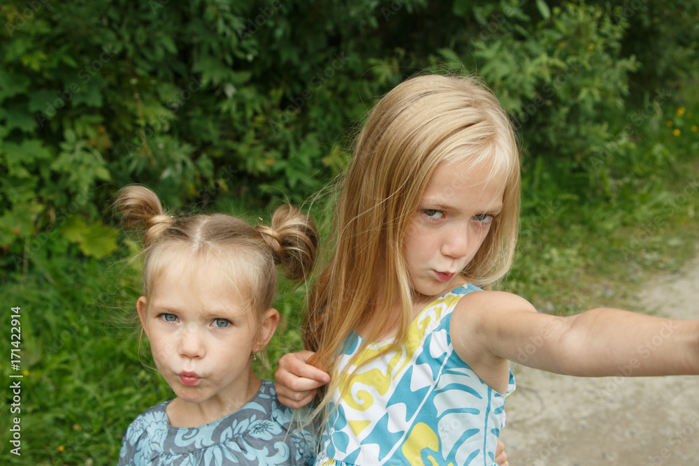 Little girls taking selfie Two sisters fooling
Little girls taking selfie Two sisters fooling