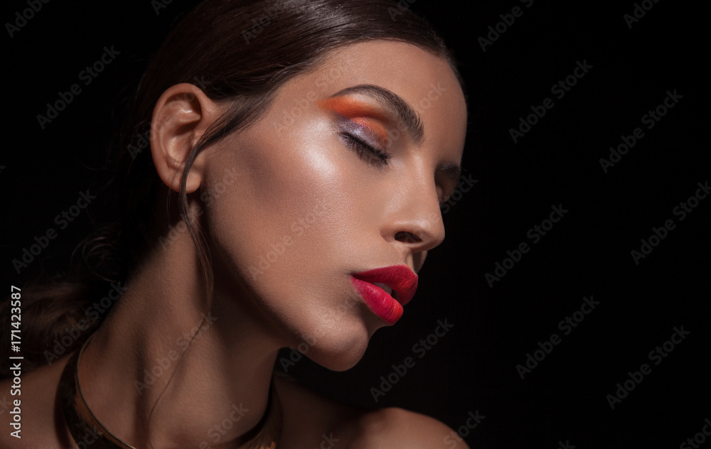 Beautiful young woman with red lips and vibrant eyeshadow on black background Beautiful young woman with red lips and vibrant eyeshadow on black background