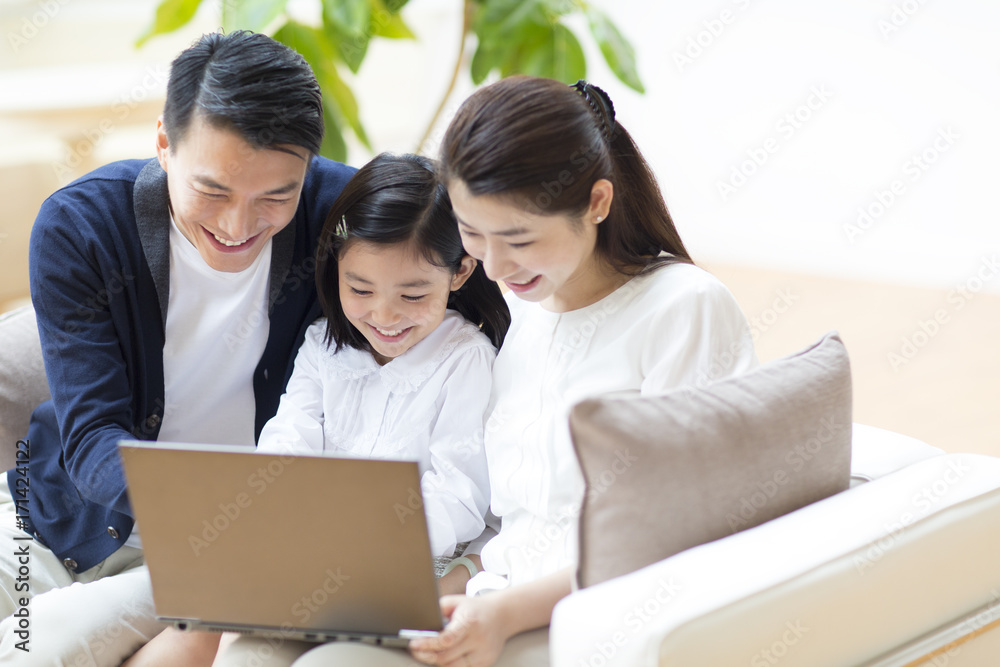 Parents and daughter looking at laptop computer Parents and daughter looking at laptop computer