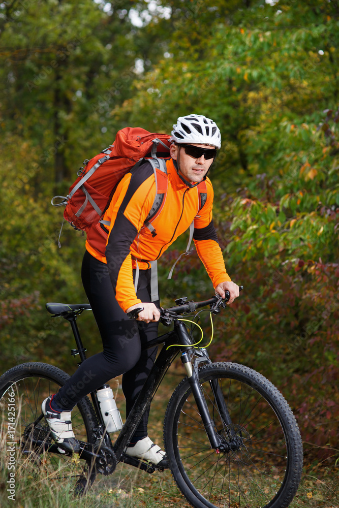 Mountain biking down the trail. Tourist with backpack travel on bike.