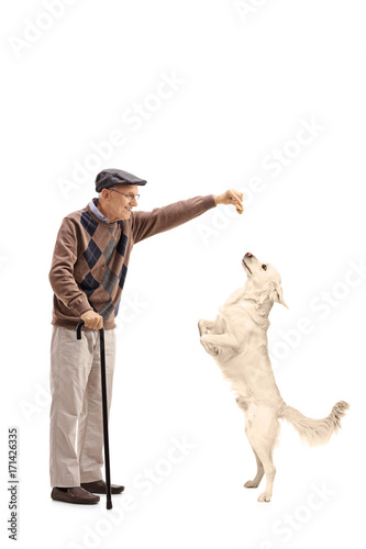 Senior giving a cookie to a dog