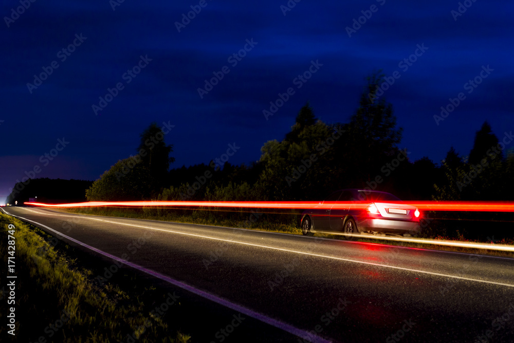 The headlights of the car are on long exposure.